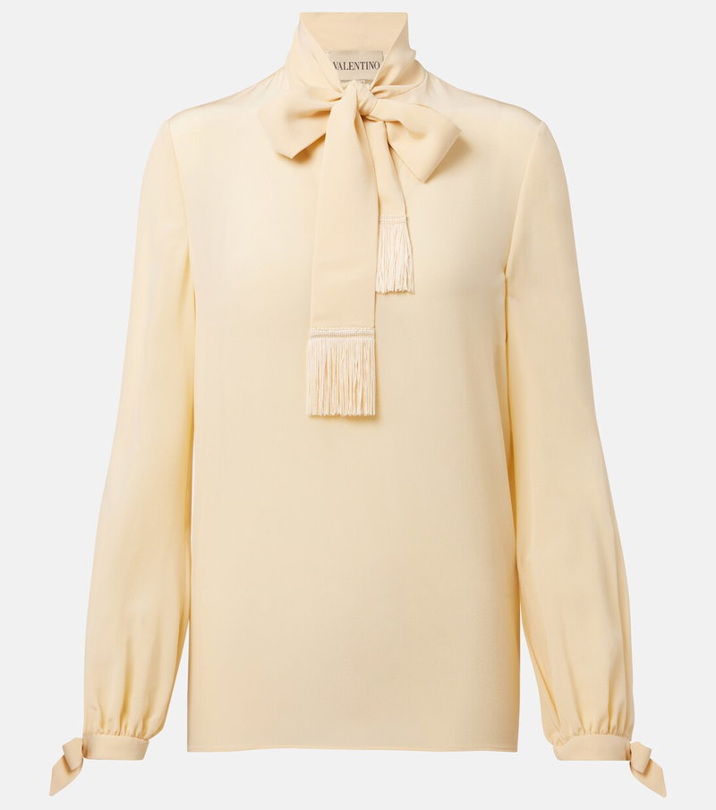 Cream silk blouse with a large bow and fringe details