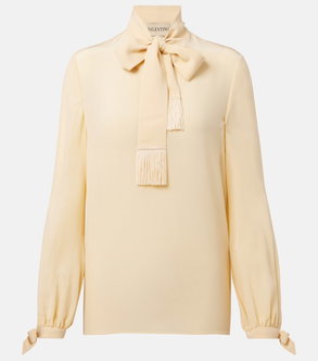 Cream silk blouse with a large bow and fringe details