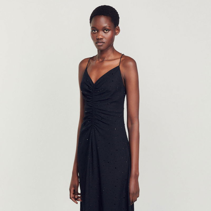Black, embellished slip dress worn by a model
