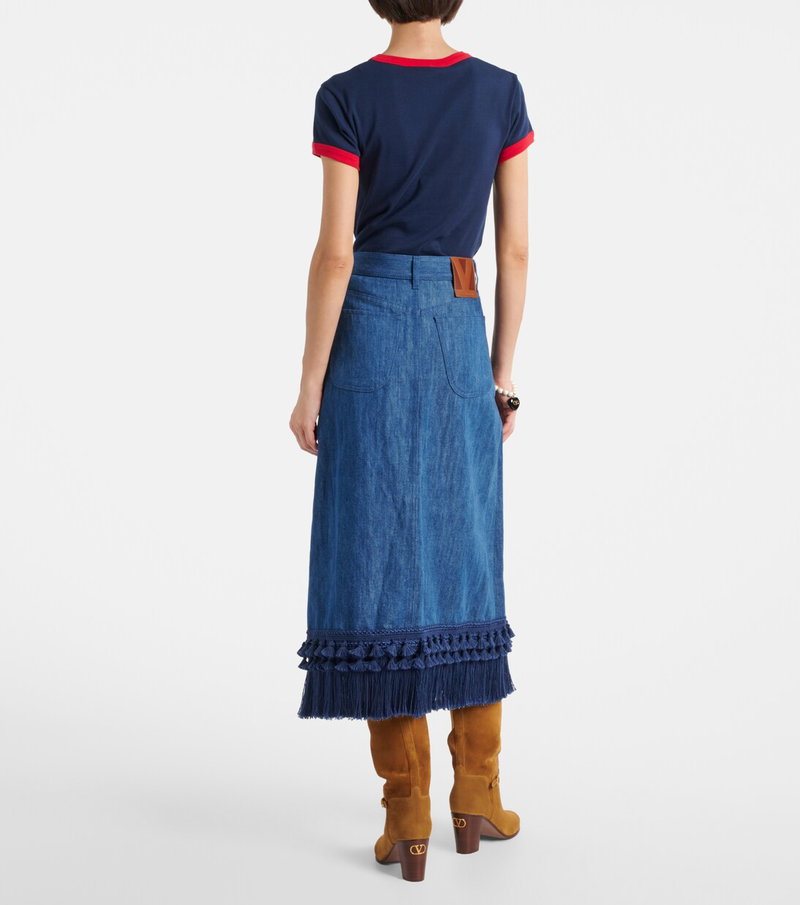 Valentino denim skirt with fringe and a woman wearing a blue t-shirt and boots.