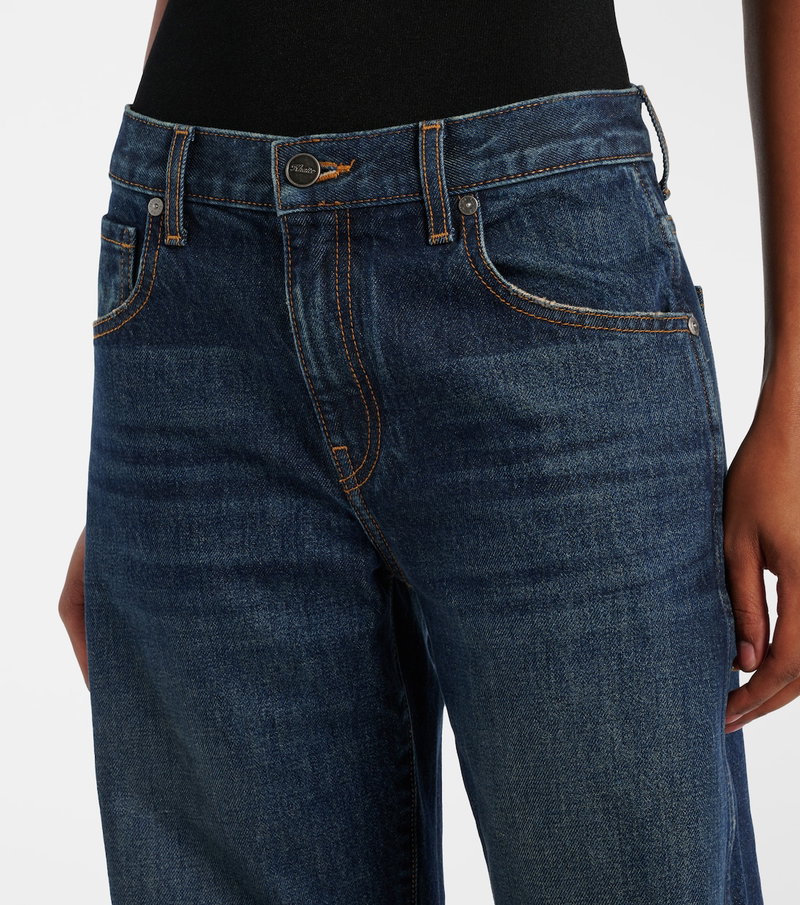 Dark wash denim jeans with orange stitching, featuring a button detail.