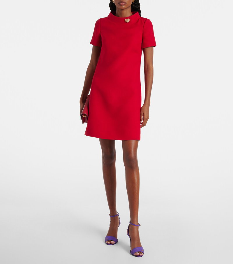 Valentino red shift dress with gold heart brooch and purple heels.