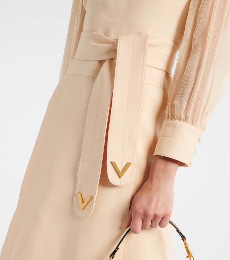 Peach-colored dress with a belted waist and gold Valentino logo.