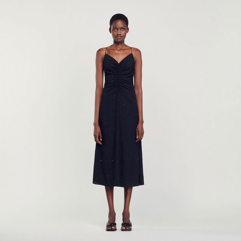 Black satin midi dress with ruched bodice and delicate straps.