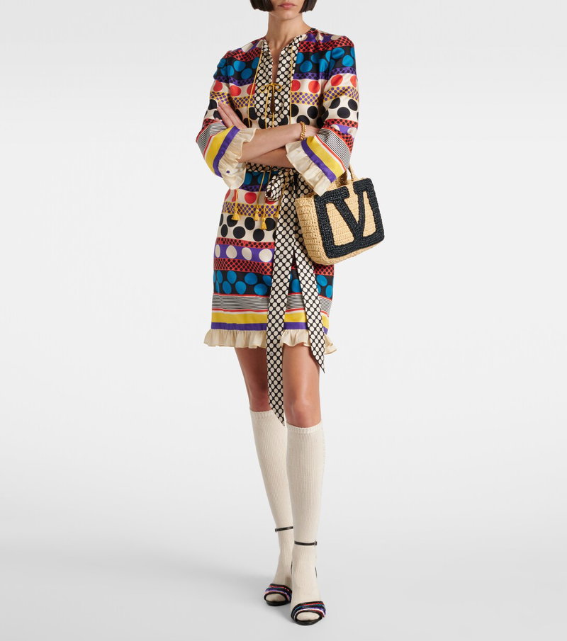 Valentino printed dress with a belted waist and straw bag.