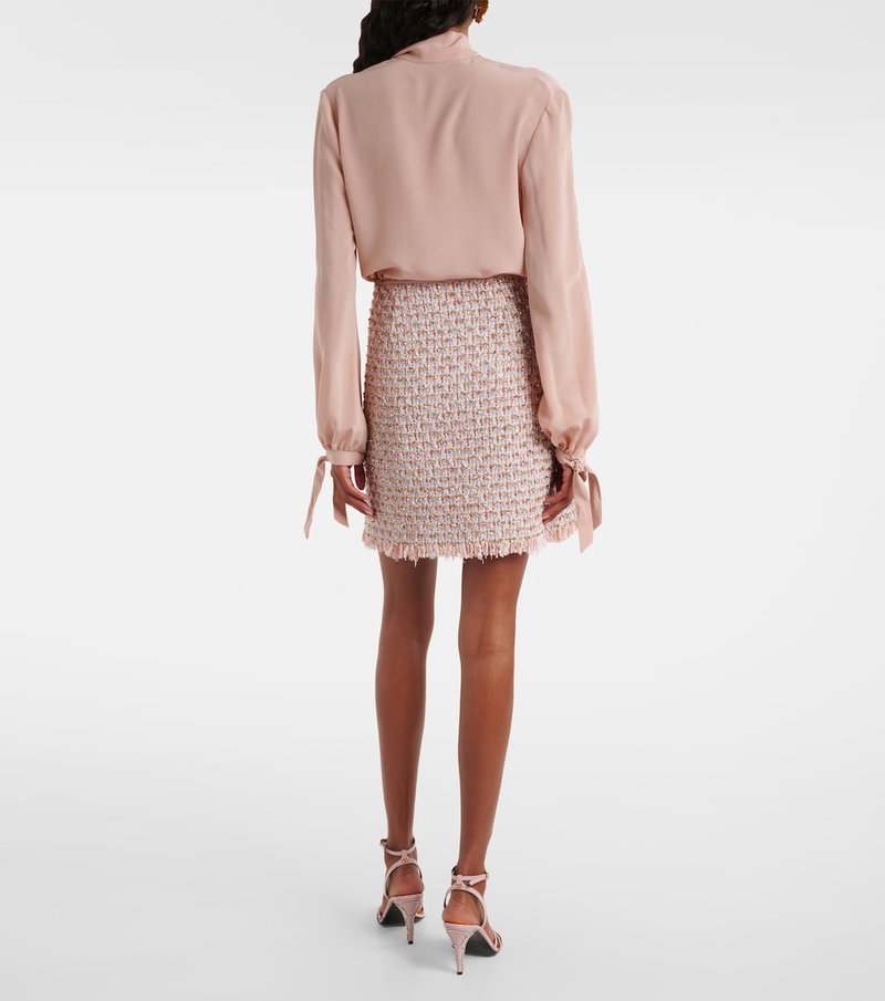 Pink silk blouse with puffed sleeves and a tweed skirt.