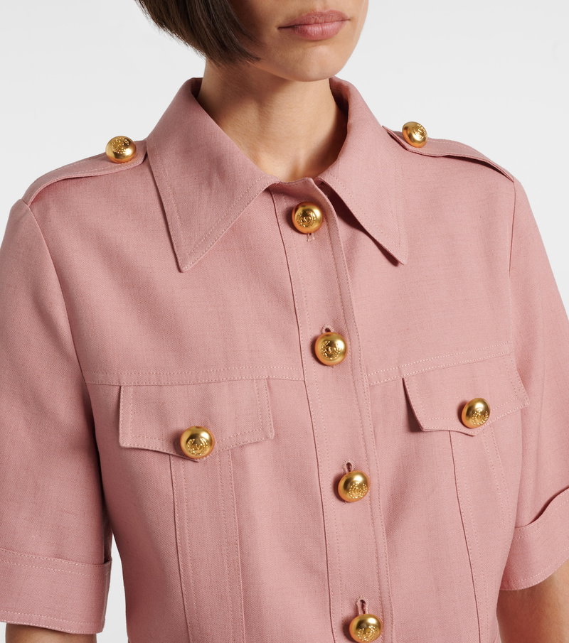 Pink linen shirt with gold buttons, close-up.