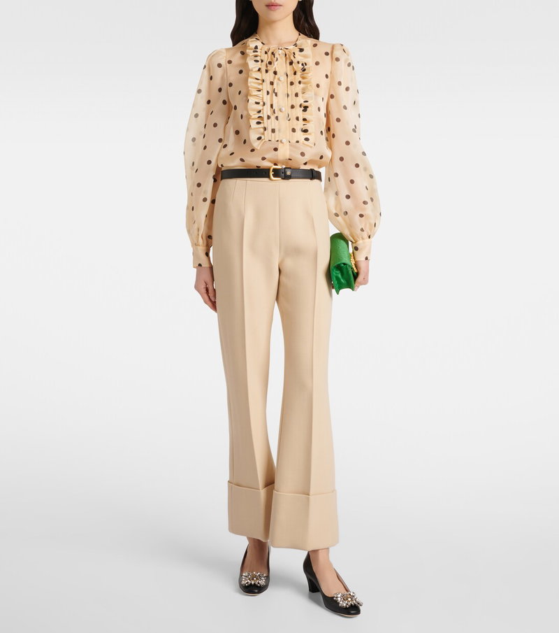 Valentino woman in a polka-dot silk blouse and beige trousers.