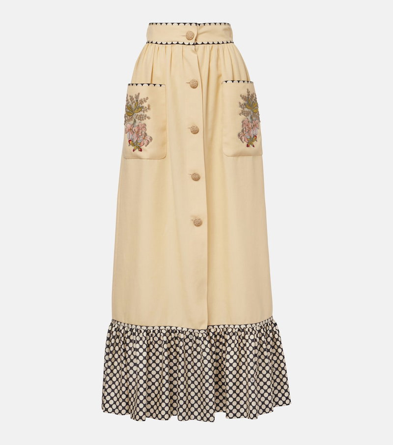 Embroidered, cream-colored high-waisted skirt with black and white polka dot hem.