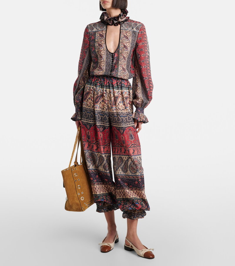 Valentino paisley jumpsuit with a drawstring waist and a crossbody bag.