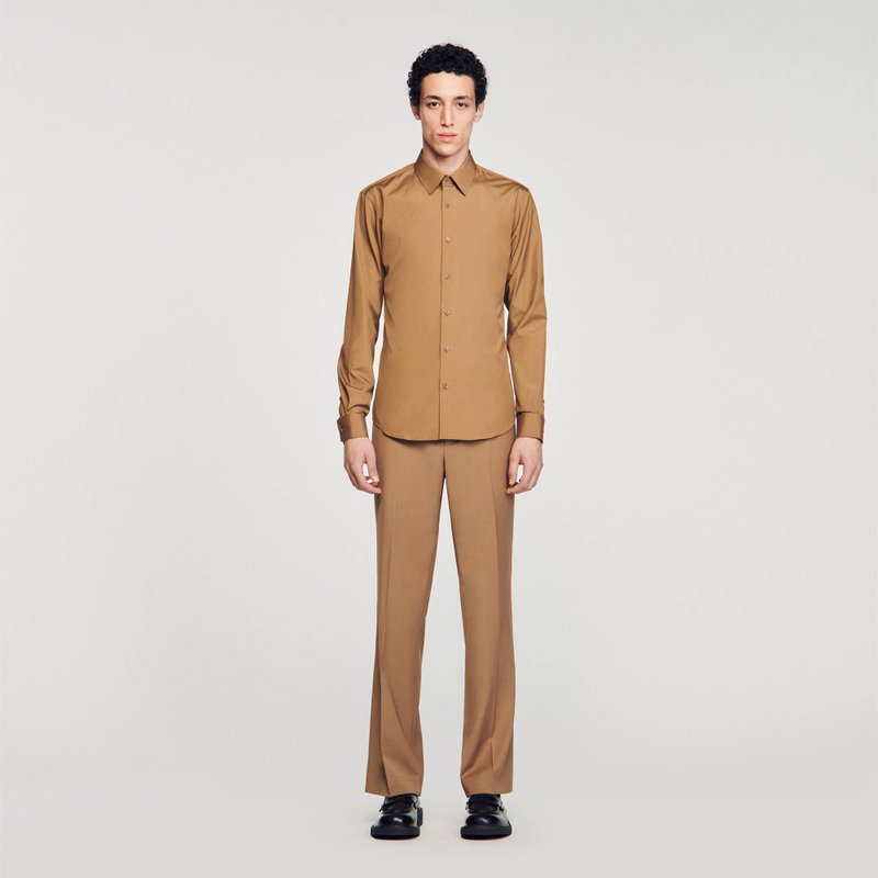 Man wearing a brown shirt and trousers.