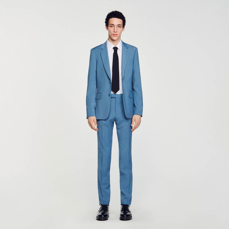 Man wearing a light blue suit and tie.