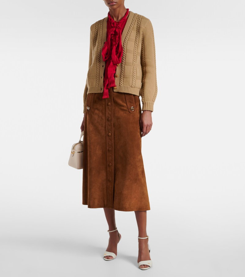 Valentino woman wearing a brown cable-knit cardigan and a red silk scarf.