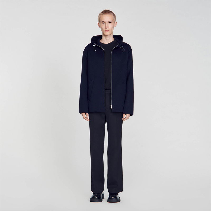 Black wool hooded jacket with zip details, worn by a model.