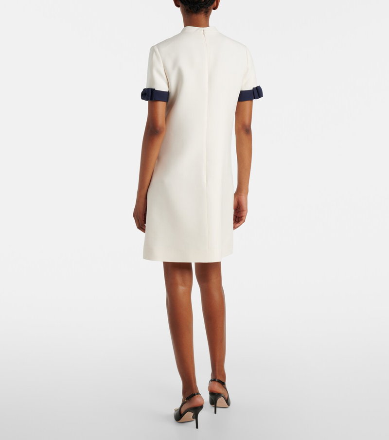 White dress with navy trim and lace sleeves.