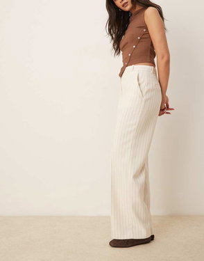 Brown ribbed knit top with button details, paired with wide-leg striped trousers.