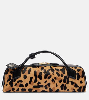 Black and leopard-print leather bowling bag with a handle and zipper detail.