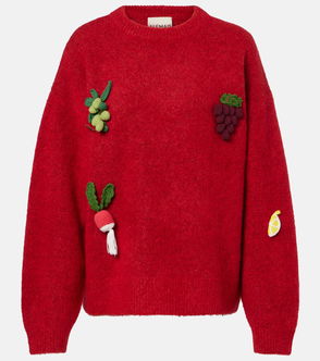 Red knitted sweater with embroidered vegetables: a radish, grapes, and a lemon.