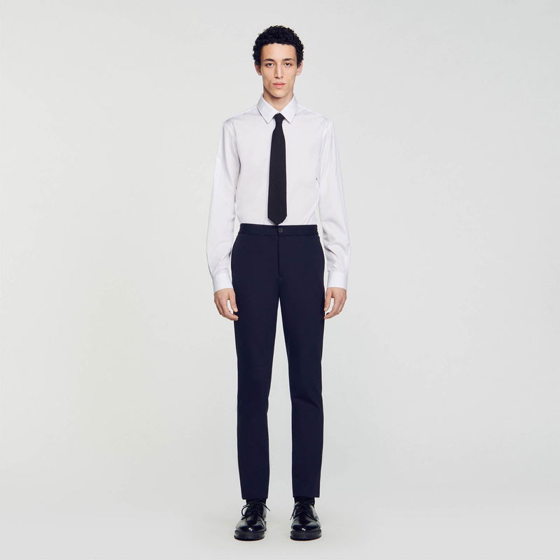 Man in SANDRO shirt and dark navy trousers