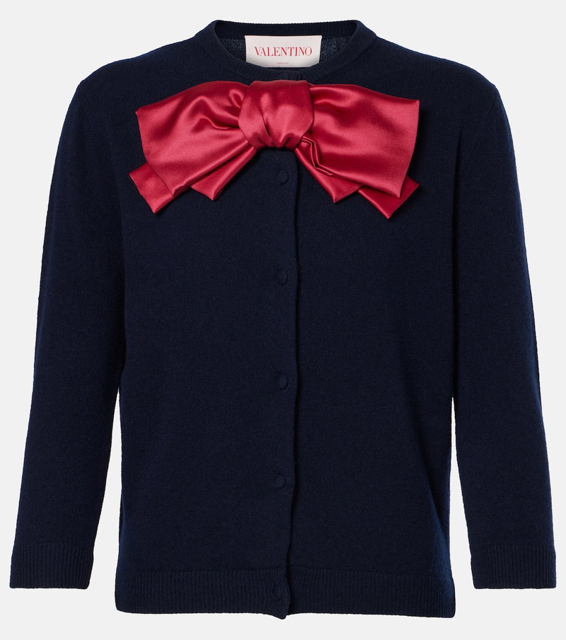 Navy cardigan with a large red satin bow.