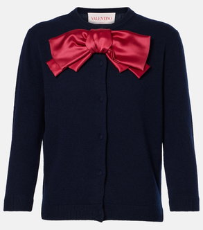 Navy cardigan with a large red satin bow.