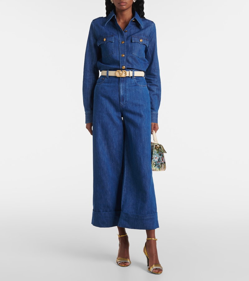Valentino blue denim jumpsuit with gold belt and handbag.