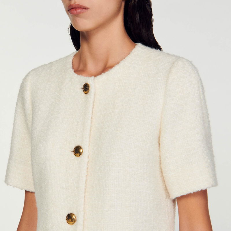 Cream-colored tweed jacket with gold buttons