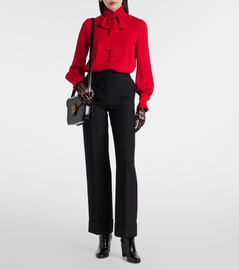 Valentino red silk blouse with lace gloves and black trousers.