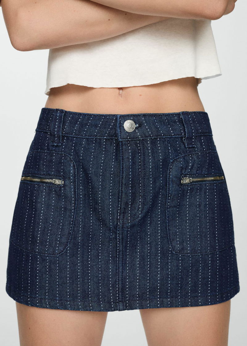 Dark blue pinstripe denim mini skirt with zipper pockets.