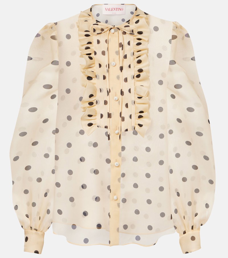Cream-colored blouse with black polka dots, ruffled neckline, and button closure.