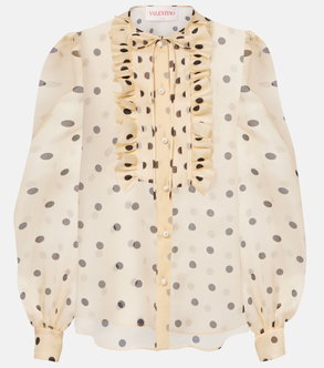 Cream-colored blouse with black polka dots, ruffled neckline, and button closure.