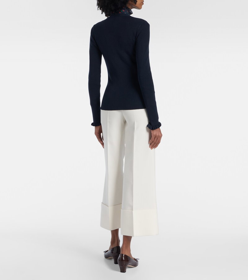 Valentino navy sweater with floral detailing and wide-leg trousers.