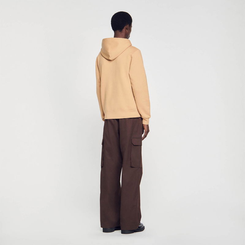Sandro man in beige hoodie and brown cargo pants
