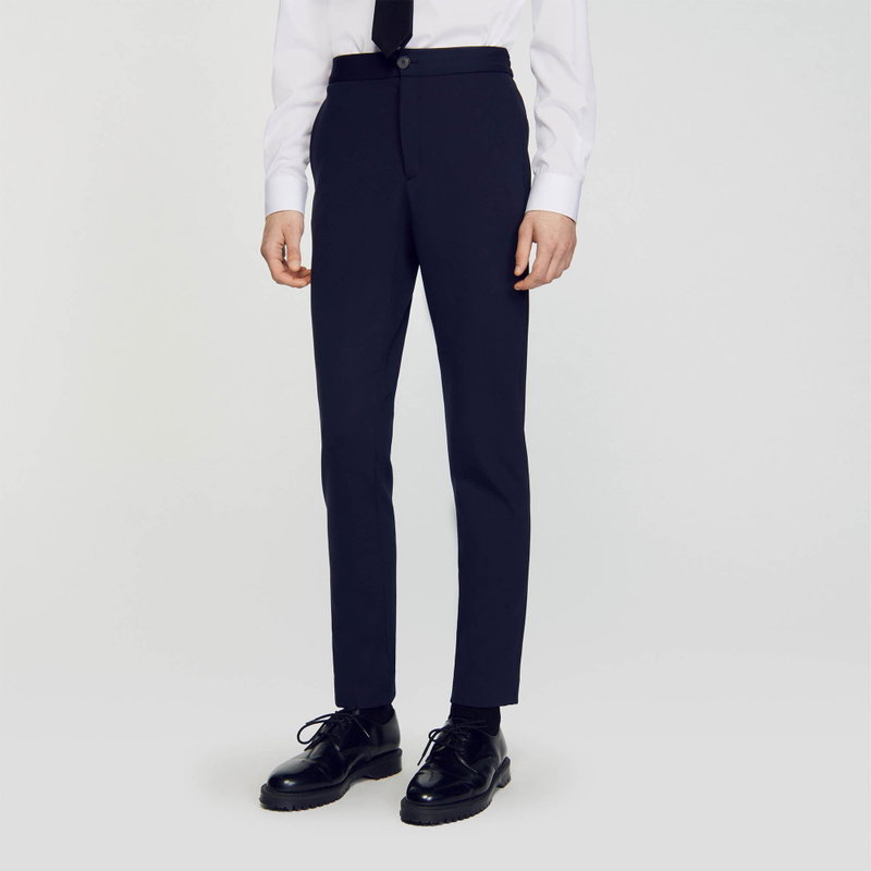 Dark navy trousers with a slim fit, worn with a white shirt and black shoes.