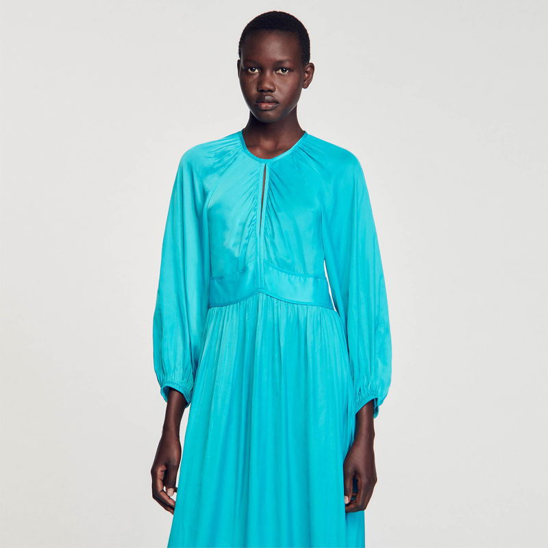 Satin turquoise dress with long sleeves and a draped neckline.