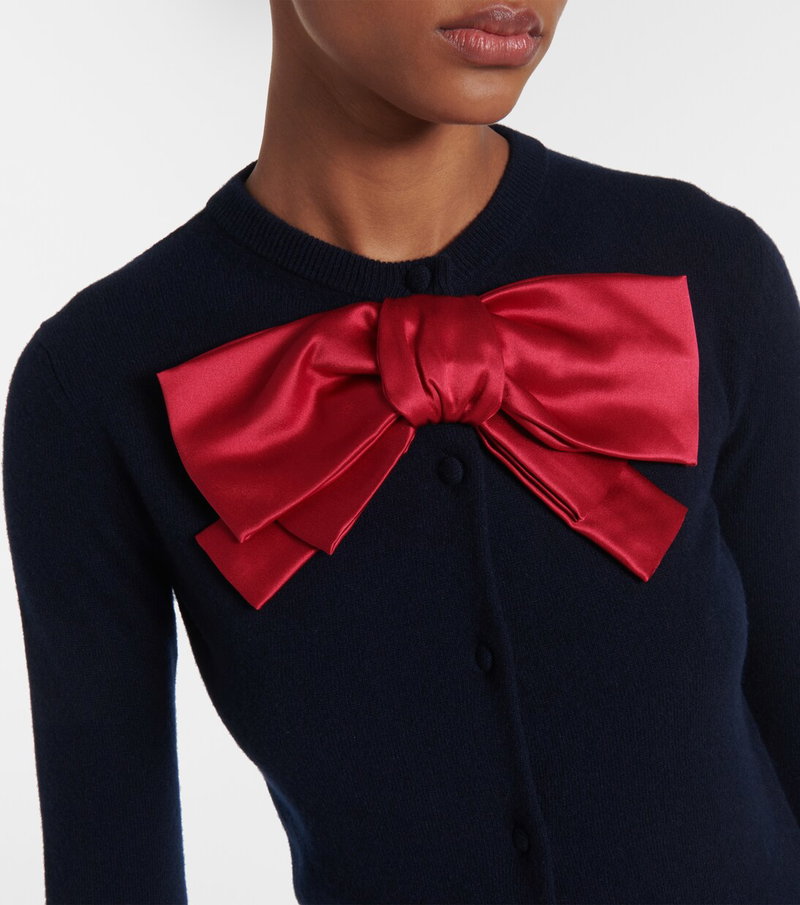 Navy sweater with a large red satin bow.