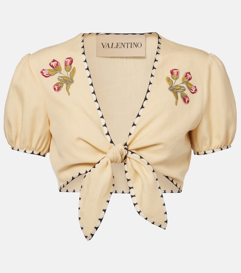 Cream-colored cropped top with floral embroidery and tie closure