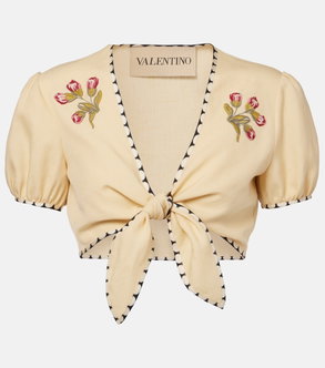 Cream-colored cropped top with floral embroidery and tie closure