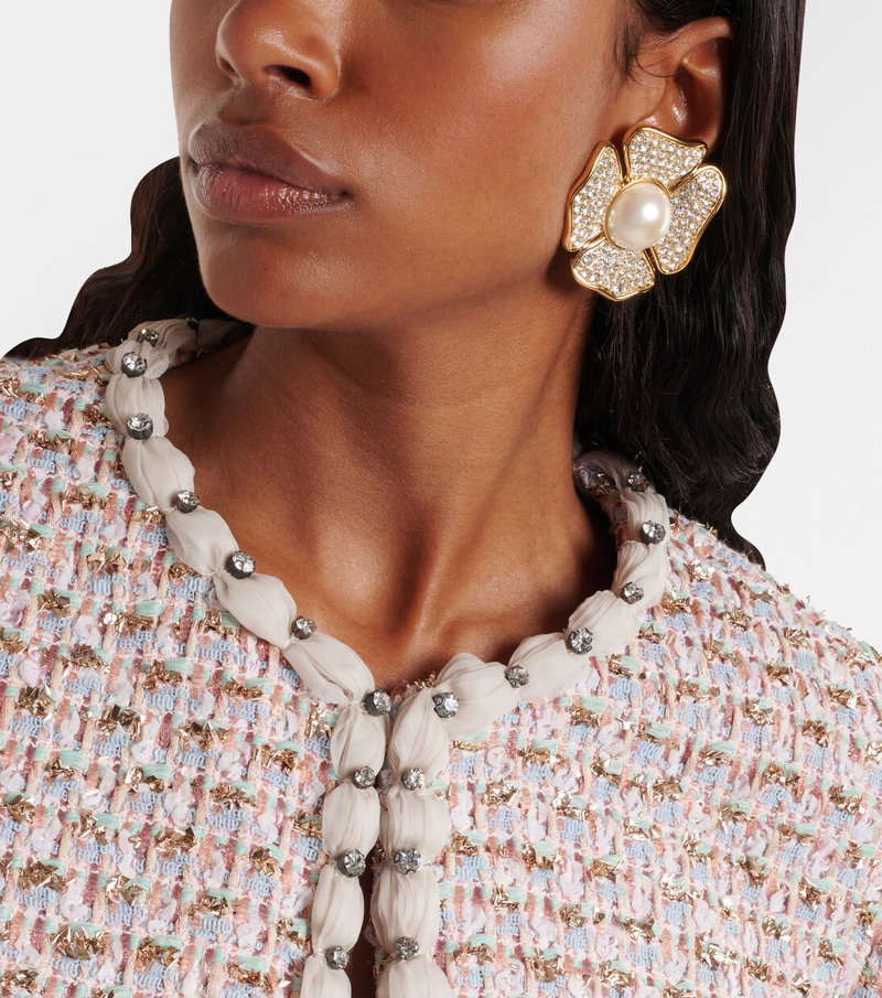 Valentino tweed jacket with pearl and rhinestone necklace, featuring a large floral earring.