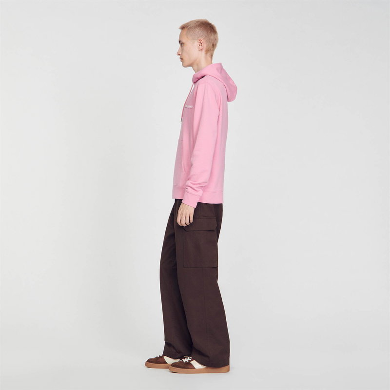Pink SANDRO hoodie with brown cargo pants and shoes.