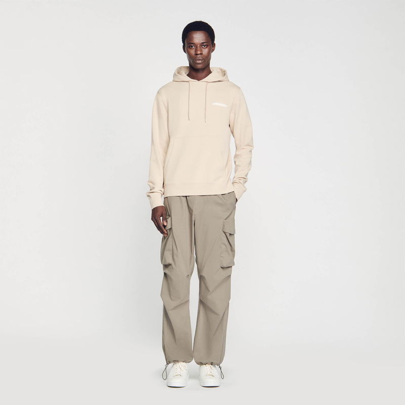 SANDRO man in beige hoodie and olive cargo pants