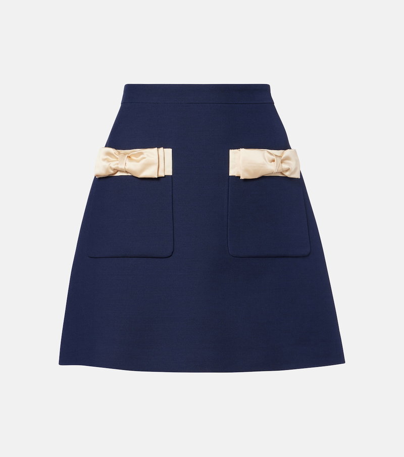 Navy satin mini skirt with cream ribbon bows and pockets
