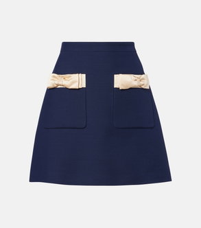 Navy satin mini skirt with cream ribbon bows and pockets