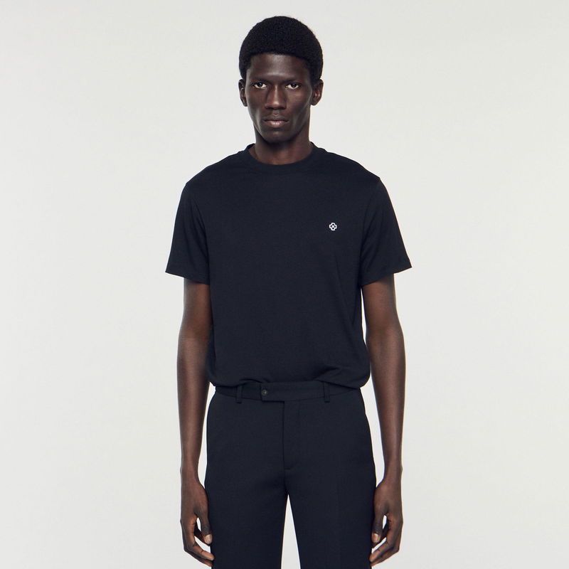 Black SANDRO t-shirt with embroidered logo, worn by a model.