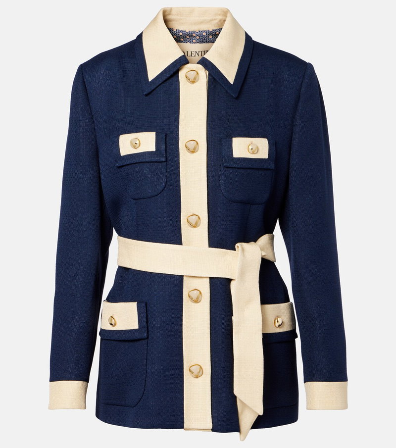 Dark blue blazer with cream-colored collar and cuffs, featuring gold buttons and a tie belt.