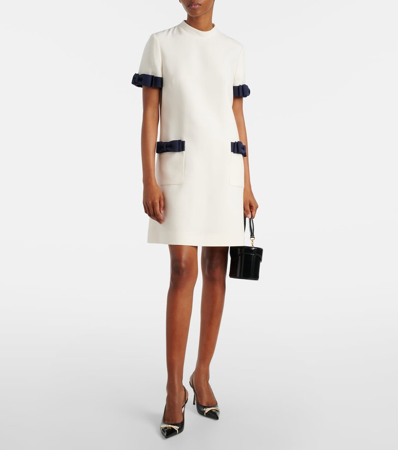 Valentino white dress with navy ribbon straps and handbag.