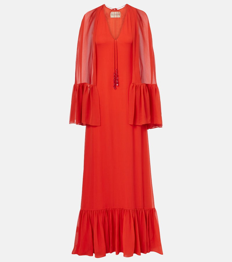 Red gown with sheer, draped sleeves and ruffled skirt.