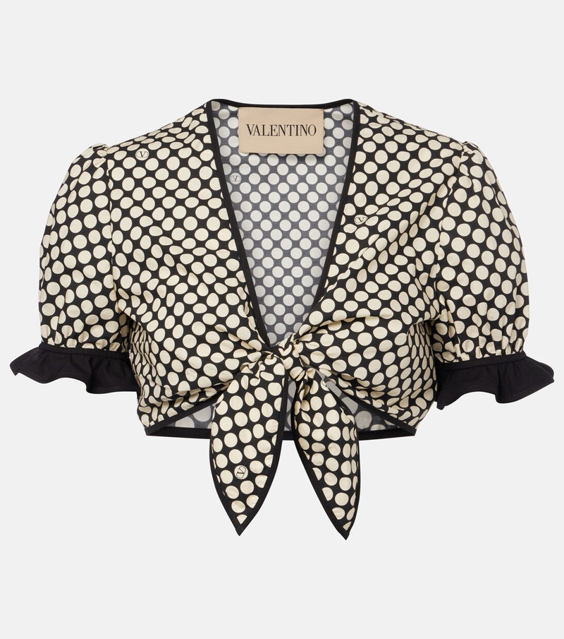 Cream polka-dot blouse with puffed sleeves and a tied bow detail.