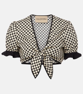 Cream polka-dot blouse with puffed sleeves and a tied bow detail.
