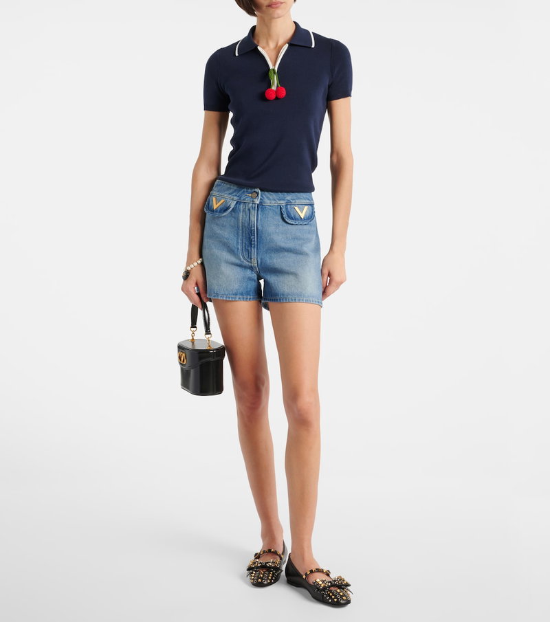 Valentino navy polo shirt with cherry accents and denim shorts.
